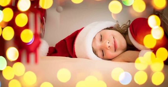 A child with a Santa hat sleeping
