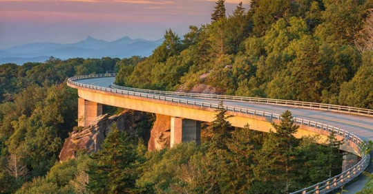 A winding road on the mountainside at sunset
