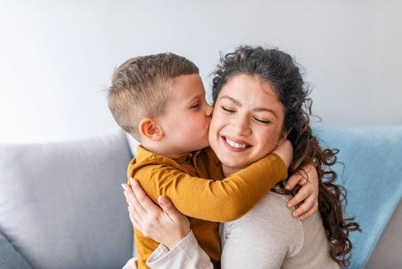 Mother and son hugging on the couch