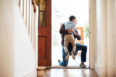 Father and son hugging at front door