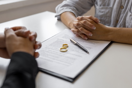 couple facing each other about to sign divorce papers
